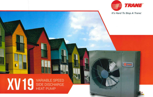 Trane XV19 variable speed side discharge heat pump unit installed next to colorful residential homes.